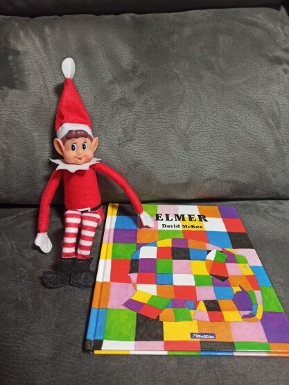 Nuestro elfo con el libro de Elmer. Lectura recomendada