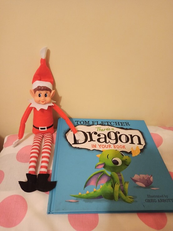 Nuestro elfo de Navidad con el libro "There's a dragon in your book"