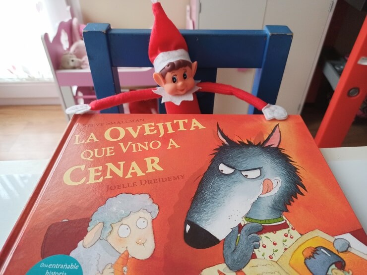 Nuestro elfo de Navidad leyendo el libro titulado "La ovejita que vino a cenar"