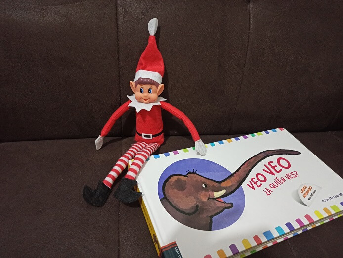 Nuestro elfo de Navidad con el libro "Veo, veo. ¿A quién ves?". Un libro de adivinanzas con ventanas desplegables.