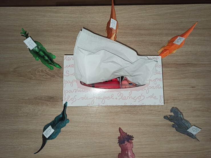 Nuestro elfo de Navidad escondido después de una noche de inocentadas sufridas por sus amigos los dinosaurios
