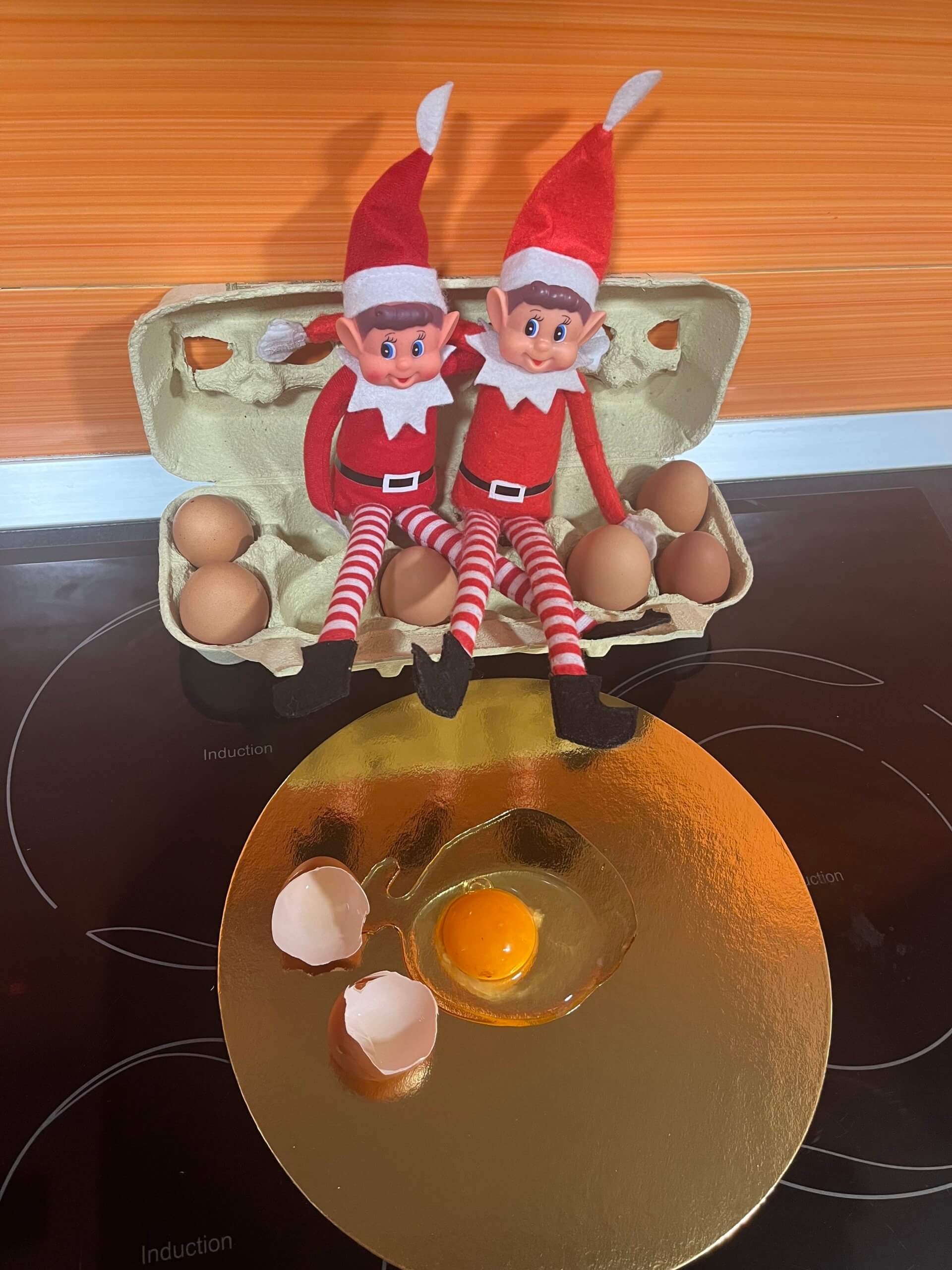 Elfos haciendo travesuras con una docena de huevos